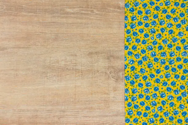 Pattern flower cloth napkin on empty wooden background. Top view with space for your text.