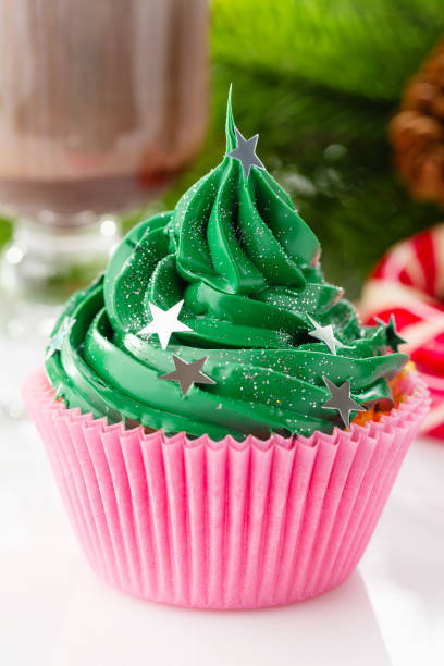 istock Green christmas cupcake with star sprinkles in pink cup 873286938