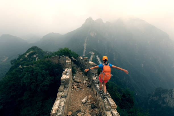 成功した女性ハイカーが山の上に万里の長城に腕を開く - tourist travel china great wall of china ストックフォトと画像