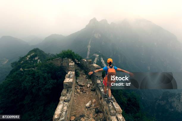 Successful Woman Hiker Open Arms To The Great Wall On The Top Of Mountain Stock Photo - Download Image Now