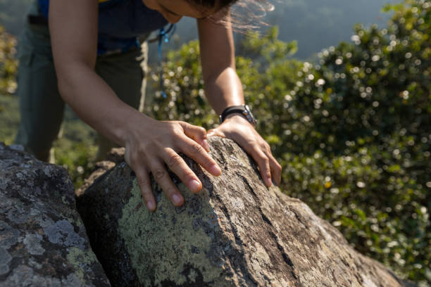 istock brave woman backpacker climbing rock to the  mountain top 873310116