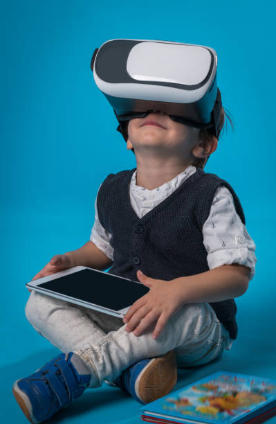 istock Casual little boy using virtual reality headsets while sitting on the floor 873310558