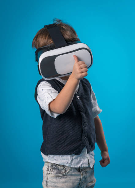 istock Casual little boy using virtual reality headsets  over colored background 873311370