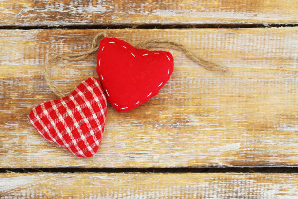 istock Red canvas hearts on rustic wooden surface with copy space 873314960