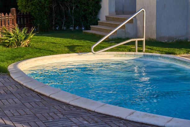 istock Swimming pool with metal stair. Blue water 873316624