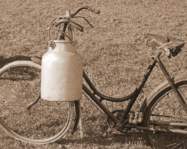 istock bicycle milkman with the old bin cans and sepia effect 873325612
