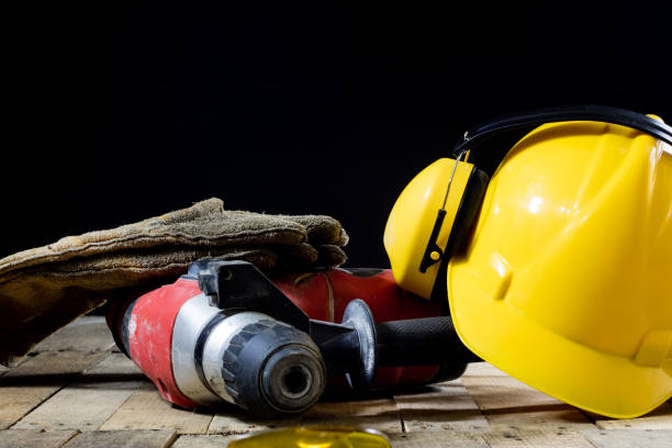istock Safety accessories and impact hammer. Accessories for a builder on a wooden table. Black background. 873328252