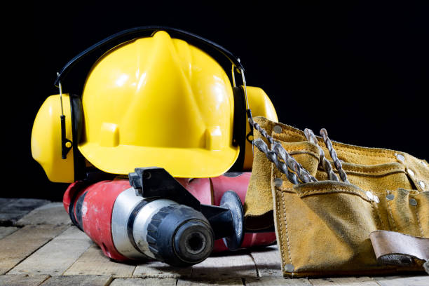 istock Safety accessories and impact hammer. Accessories for a builder on a wooden table. Black background. 873328254