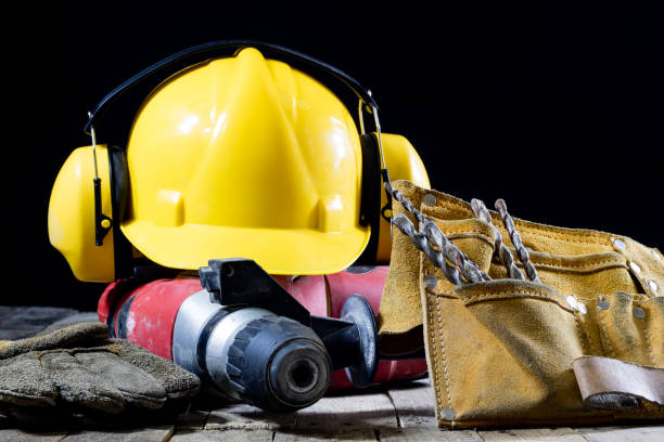 istock Safety accessories and impact hammer. Accessories for a builder on a wooden table. Black background. 873328260