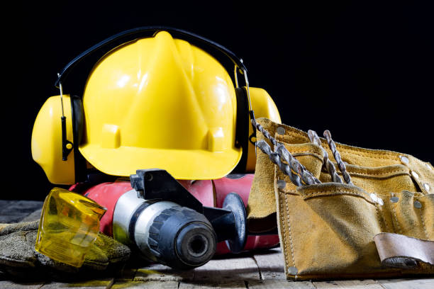 istock Safety accessories and impact hammer. Accessories for a builder on a wooden table. Black background. 873328268