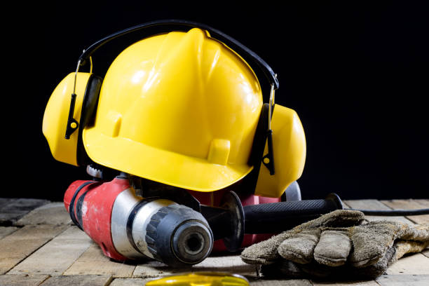 istock Safety accessories and impact hammer. Accessories for a builder on a wooden table. Black background. 873328274