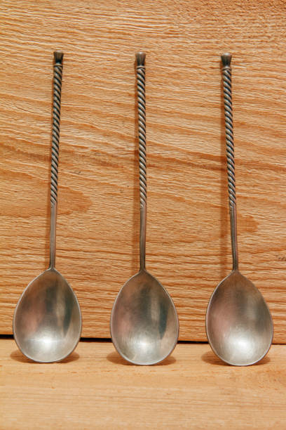 istock Vintage silver spoons with twisted handleon a wooden background 873332600