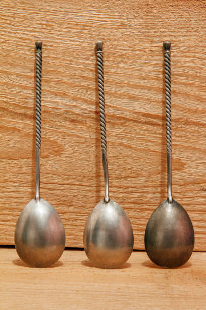 istock Vintage silver spoons with twisted handleon a wooden background 873332806