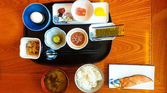 Serving sice of grilled  salmon, rice, squid, miso soup, egg and pickel. Hokkaido, Japan.