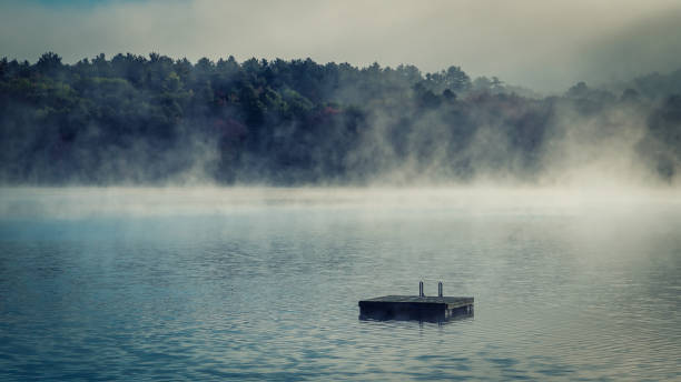 automne sur un lac avec un quai flottant - italian lake district photos et images de collection