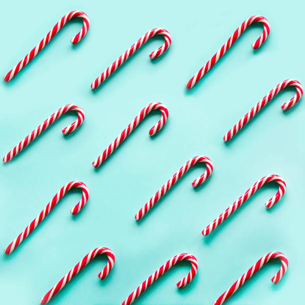 Merry Christmas candy can in row on blue background. Flat lay. Square image.