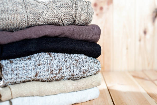 istock Knitted winter clothes and wool sweaters on wood background. Copyspace,. 873339462