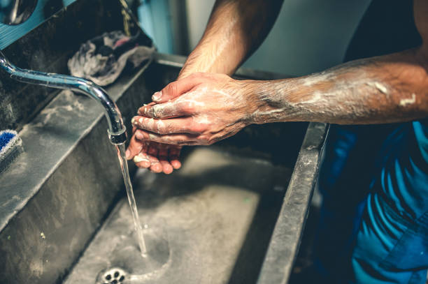Worker in factory washing their hands. stock photo