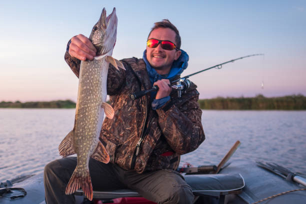 istock Happy amateur angler holds Pike fish 873359260