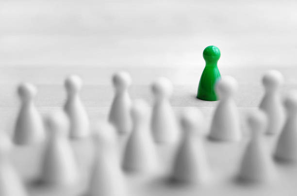 Leadership and management concept. Boss, chief or executive in front of crowd or group. Public speaking and giving presentation. Board game pawns on wooden table.