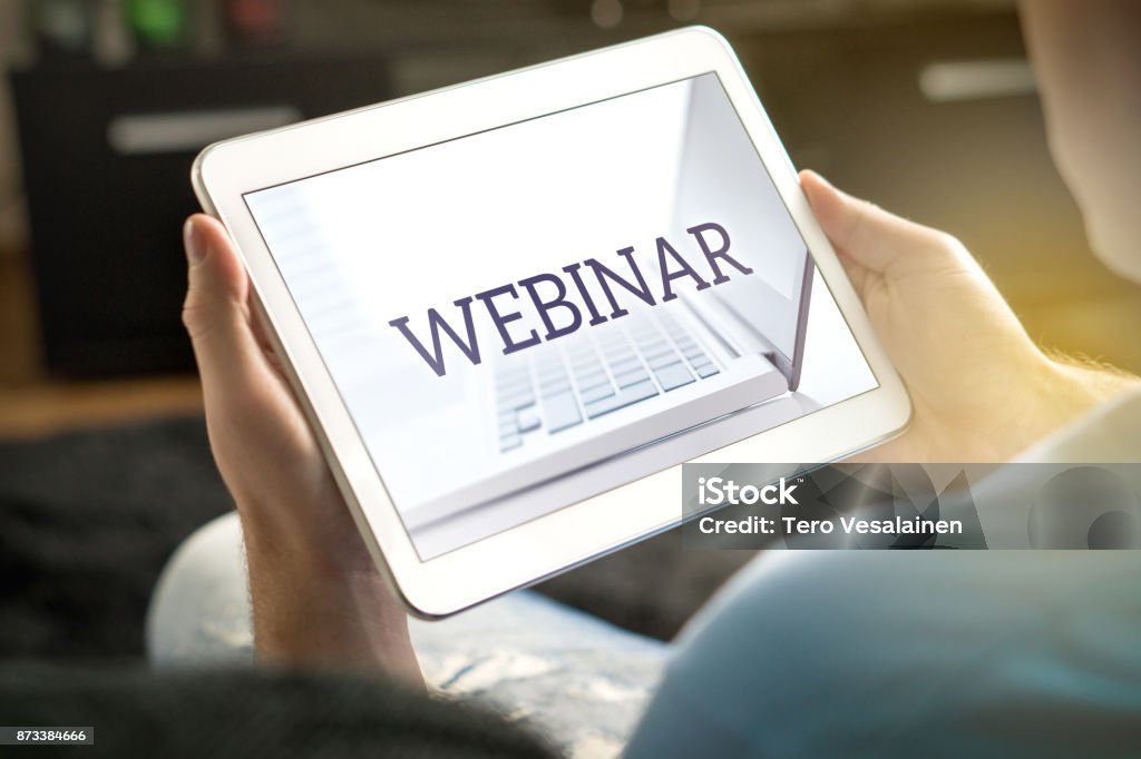 Webinar on tablet screen. Webinar on tablet screen. Man holding smart mobile device and participating in a web seminar. Adult Stock Photo