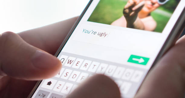 Internet troll sending mean comment to picture on an imaginary social media website with smartphone. Internet troll sending mean comment to picture on an imaginary social media website with smartphone. Cyber bullying and bad behavior online concept. furious stock pictures, royalty-free photos & images