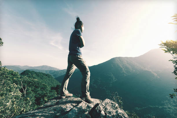 istock successful young woman enjoy the view on cliff's edge 873388984