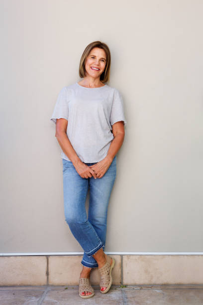 istock smiling elderly woman leaning against wall 873392830