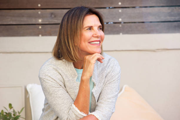istock attractive woman sitting outside and smiling 873392882