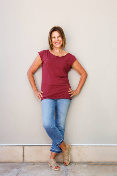 istock senior woman smiling against wall 873392908