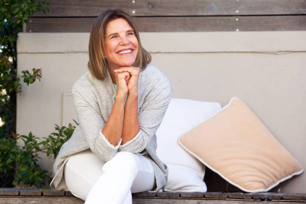 istock happy woman sitting outside looking away 873392996