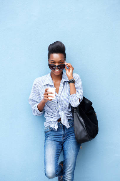 istock cool young woman smiling with purse and coffee cup 873393040