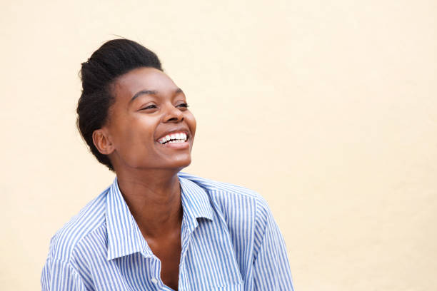 istock beautiful young black woman laughing against wall 873393058