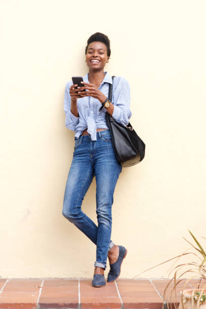 istock smiling black woman using mobile phone 873393088