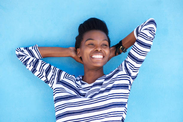 istock smiling young black woman with hands behind head 873393098