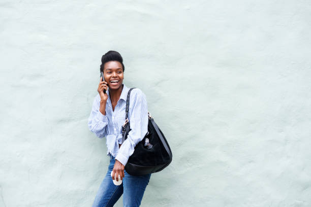 istock young black woman laughing and talking on cellphone 873393110