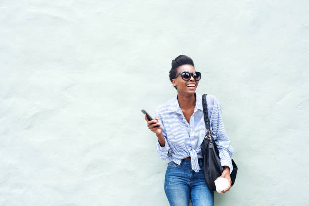 istock young modern woman laughing with mobile phone 873393116