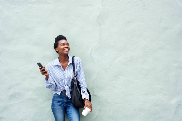 istock happy black woman holding mobile phone 873393138