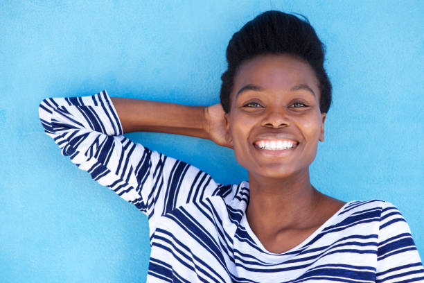 istock happy young black woman smiling with hand behind head 873393174