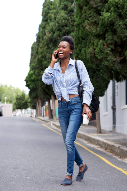 istock young woman talking and walking with mobile phone 873393208
