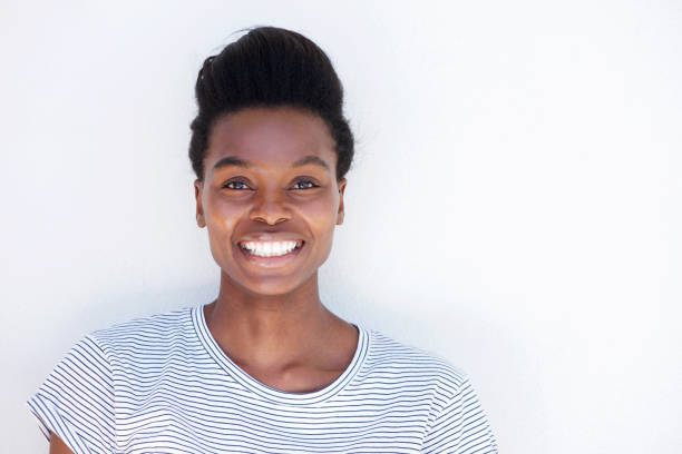 istock beautiful young black woman smiling against white wall 873393218