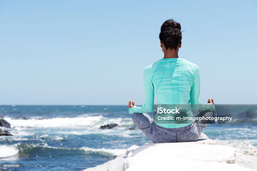 behind of yoga woman at the beach Portrait from behind of yoga woman at the beach Beach Stock Photo