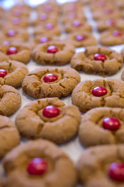 Background image of freshly backed sugar topped ginger cookies with a red chocolate center piece.