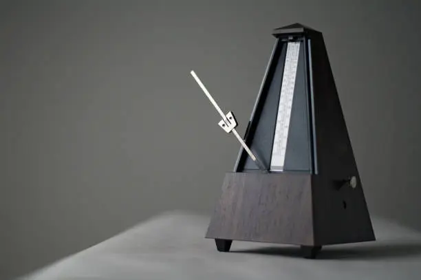 Monochromatic metronome in action isolated and on a plain background.  Calgary, Alberta, Canada.