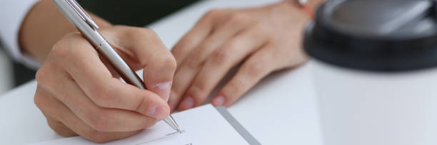 istock Female hand holding silver pen ready to make 873396586