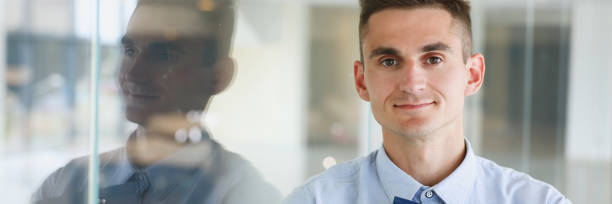 istock Handsome man in shirt and folder stand 873396876