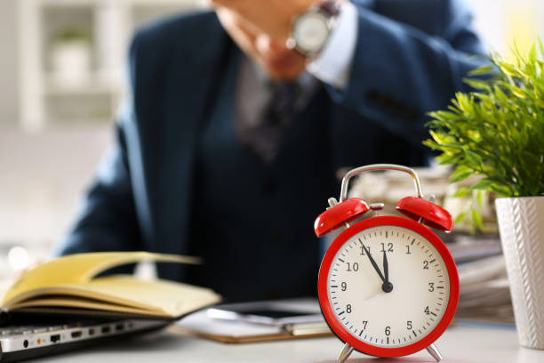 istock Red alarm clock shows late time closeup 873397568