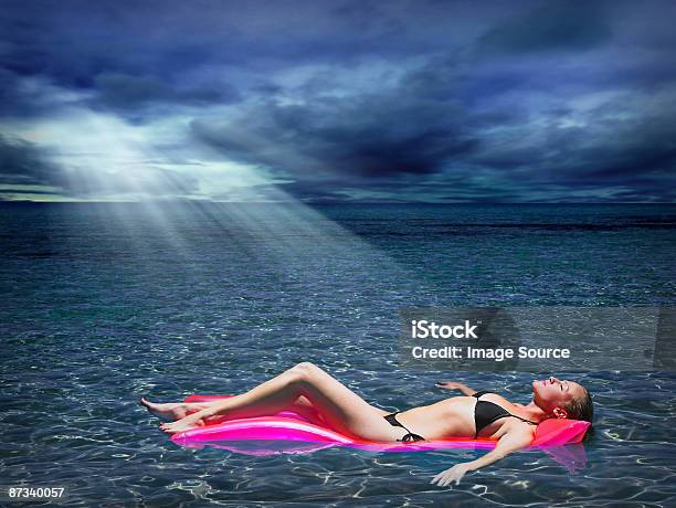 Mujer En Un Colchón Inflable En El Mar Foto de stock y más banco de imágenes de Acostado - Acostado, Adulto, Adulto joven