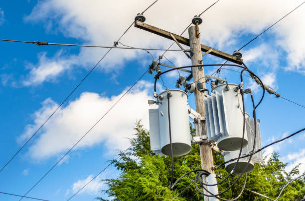 Electricity Pole with Transformers and Blue Sky Photo of Electricity Distribution Pole with Transformers aginst Bleu Sky with Clouds transformer stock pictures, royalty-free photos & images