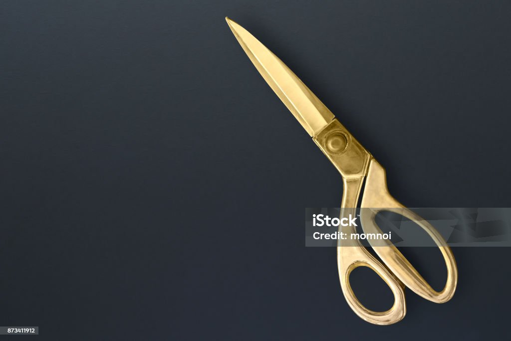 Dressmaking scissors on black board Sewing Scissors or tailoring scissors Titanium professional for heavy duty isolated on black board background. Dressmaking scissors on black board Scissors Stock Photo